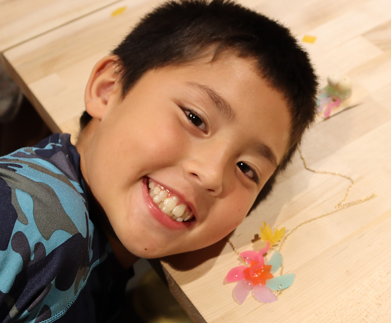 a child smiling with their craft project background image